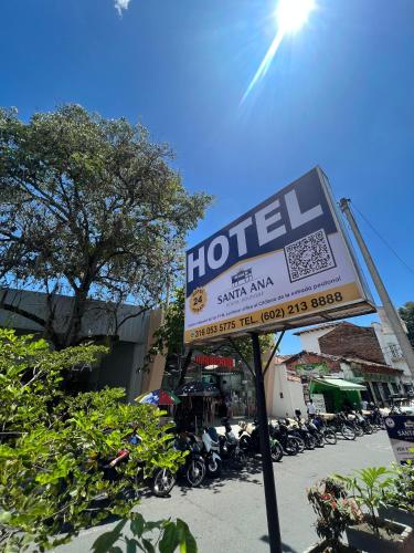 a sign for a hotel with motorcycles parked in a parking lot at Hotel Boutique Santa Ana in Cartago