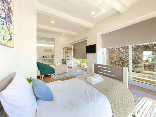 a bedroom with a white bed and a large window at Capelas House Family in Capelas