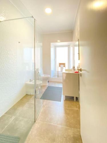 a bathroom with a shower and a sink and a toilet at Capelas House Family in Capelas