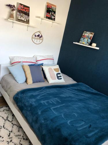 Una cama con una manta azul en una habitación en Chambre d hôte spéciale évènements sur circuit 24h du Mans, en Mulsanne