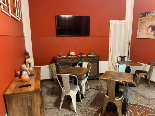 comedor con mesas y sillas de madera y TV de pantalla plana en Hotel Nice, en Viareggio