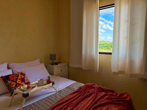 a bedroom with a bed and a window with a tray on it at Apê Central Bonito in Bonito