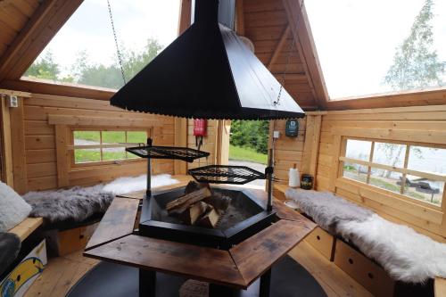 ein Wohnzimmer mit einem Kamin in einer Blockhütte in der Unterkunft Villa Granbacka Raasepori Karjaa Finland in Karjaa