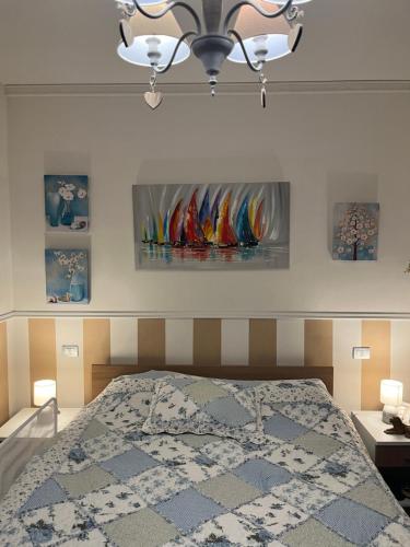 1 dormitorio con 1 cama y pinturas en la pared en Nella natura a due passi dal mare a casa di Francy, en Numana