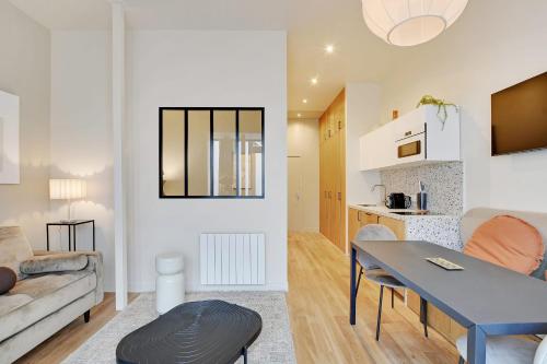- un salon avec un canapé et une table dans l'établissement Charming 1-BEDR Parisian Apartment in Vibrant Rue d'Hauteville, à Paris