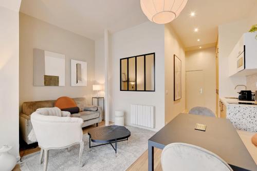 - un salon avec un canapé et une table dans l'établissement Charming 1-BEDR Parisian Apartment in Vibrant Rue d'Hauteville, à Paris