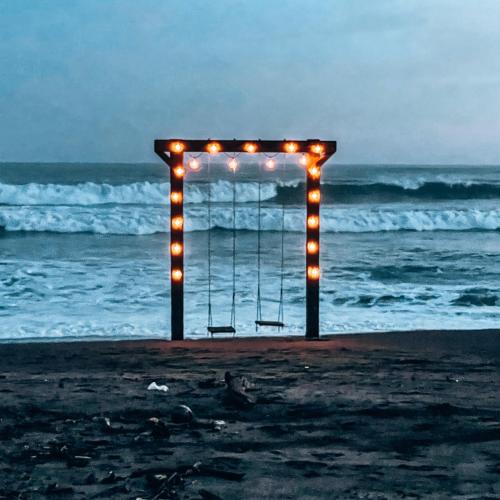 an arch with lights on the beach at night at El Sitio de Playa Venao in Playa Venao