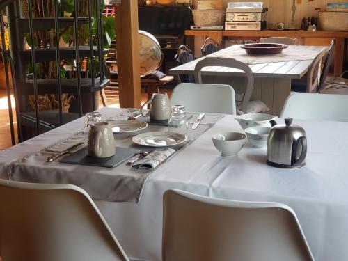 a white table with silver utensils on it at Maison de Paille in Ceton