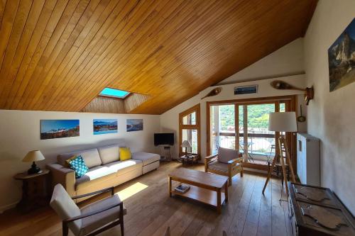 a living room with a couch and a wooden ceiling at Apartment with view of Prorel in Briançon