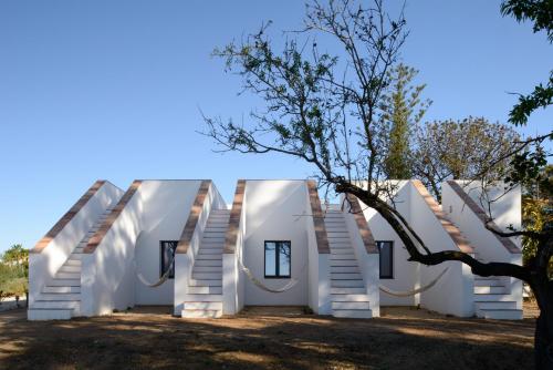 a house with white walls and stairs at Casa Modesta in Olhão