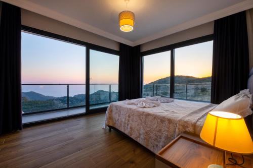 a bedroom with large windows with a bed and a lamp at Villa Butterfly in Fethiye