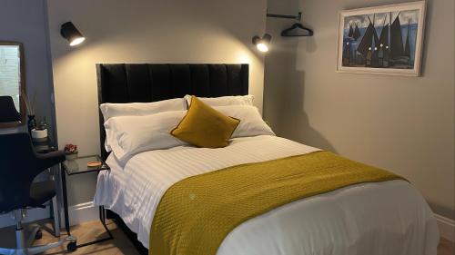 ein Schlafzimmer mit einem großen Bett und einem gelben Kissen in der Unterkunft CityGo Apartments Queens in Belfast