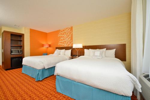 duas camas num quarto de hotel com paredes cor de laranja em Fairfield Inn & Suites by Marriott Elmira Corning em Horseheads