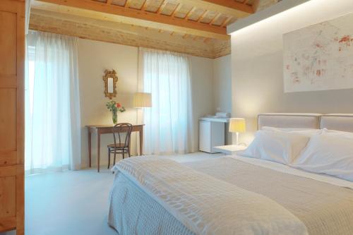 a white bedroom with a bed and a desk at Piccola Dimora Gherardini in SantʼElpidio a Mare