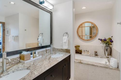 a bathroom with two sinks and a large mirror at Edgemont 2602 - Luxury Ski-in Ski-out Condo in Steamboat Springs