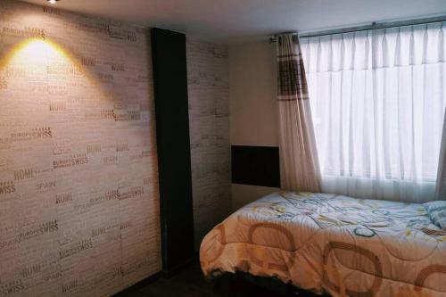 a bedroom with a bed next to a window at Departamento: Mirador de Puno. in Puno