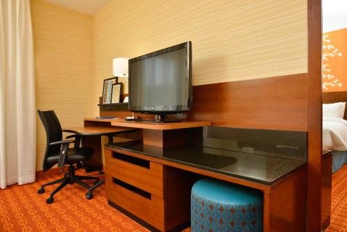 a hotel room with a desk with a television at Fairfield Inn & Suites by Marriott Elmira Corning in Horseheads