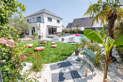 een tuin met een zwembad en een huis bij Le Gîte des Dames - 6 personnes PISCINE chauffée in La Ville-aux-Dames