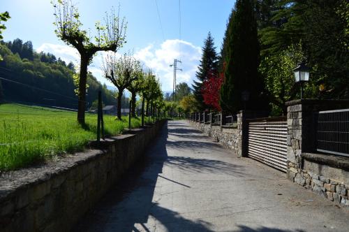 a long road with a stone wall and trees at Hostal l'Escon in Llanars