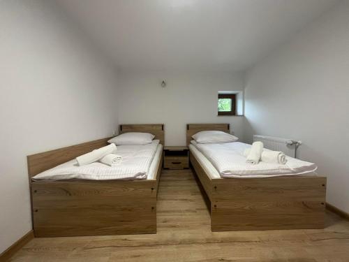 two twin beds in a room with white walls at Apartamenty Wadowity- Energylandia Zator in Wadowice