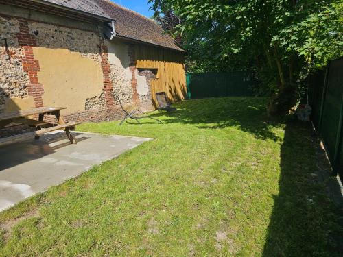 a bench sitting in the grass next to a building at Ma p'tite cabane in Neufmarché
