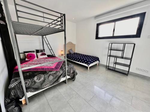 une chambre avec deux lits superposés et une fenêtre dans l'établissement Villa / Maison indépendante 150m de la plage avec jacuzzi et piscine chauffée à Saint Cyprien plage, à Saint-Cyprien