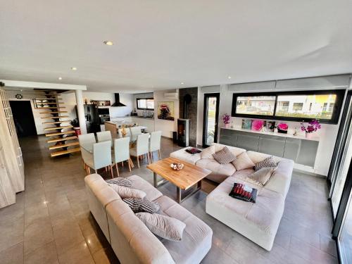 un salon avec des canapés et une table ainsi qu'une cuisine dans l'établissement Villa / Maison indépendante 150m de la plage avec jacuzzi et piscine chauffée à Saint Cyprien plage, à Saint-Cyprien