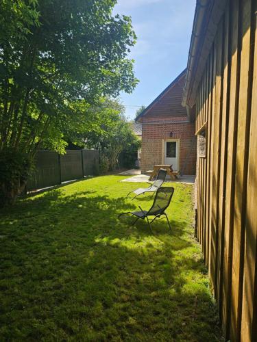 a bench sitting in a yard next to a building at Ma p'tite cabane in Neufmarché