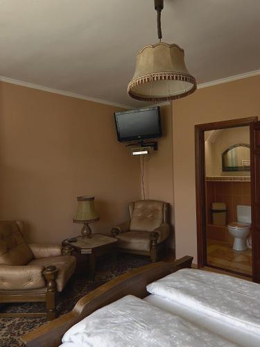 a bedroom with a bed and a tv and a chair at Вілла де Кампо in Chynadiyovo