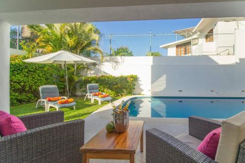 a patio with a table and chairs and a pool at Casa Jocelyne Alberca Privada in Puerto Vallarta