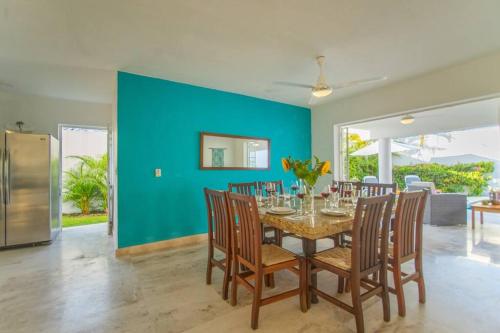 a dining room with a table and chairs and a blue wall at Casa Jocelyne Alberca Privada in Puerto Vallarta