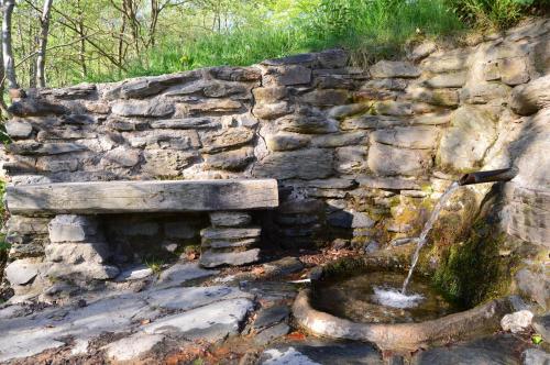 a stone wall with a fountain with a stone bench at Hostal l'Escon in Llanars
