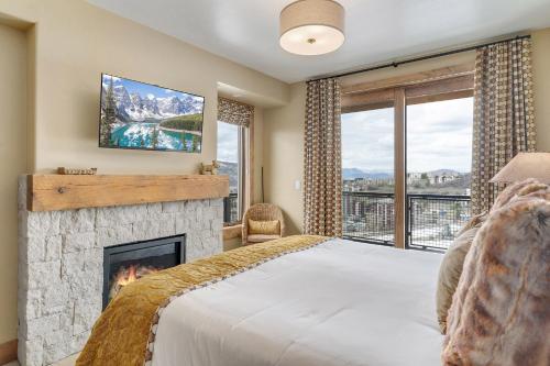a bedroom with a fireplace and a tv and a bed at Edgemont 2600 - Luxury Ski-in Ski-out Condo in Steamboat Springs