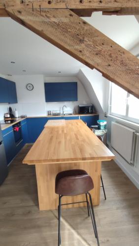 une table en bois dans une cuisine avec une chaise en bois dans l'établissement Malo les bains Appt à 7 minutes de la plage, à Dunkerque