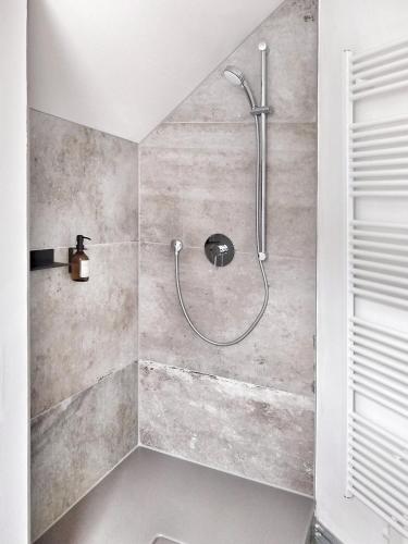 a shower with a shower head in a bathroom at Über den Dächern der Altstadt in Rostock