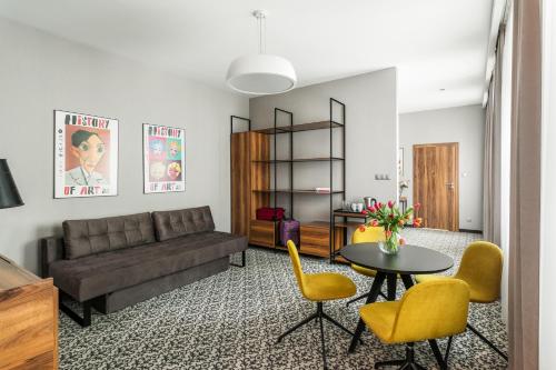 a living room with a couch and a table and chairs at No.23 Premium Aparthotel in Krakow