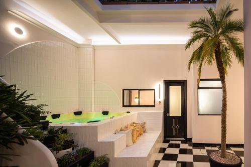 um átrio com uma banheira e uma palmeira em HOLT Hotel De Mi Independencia Double Queen Room em Oaxaca de Juárez