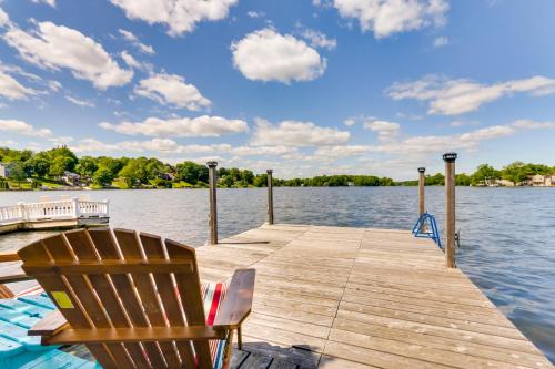 a wooden dock with a chair on the water at Lakefront Home, Close to Mt Southington! in Wolcott