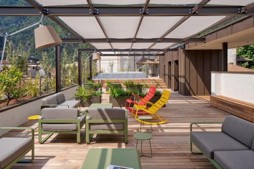 a patio with colorful chairs and tables on a deck at Hotel Giardino Verdi in Riva del Garda