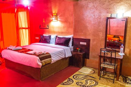 a bedroom with a bed in a red room at Palais Ksar Lamane in Aït Ben Haddou