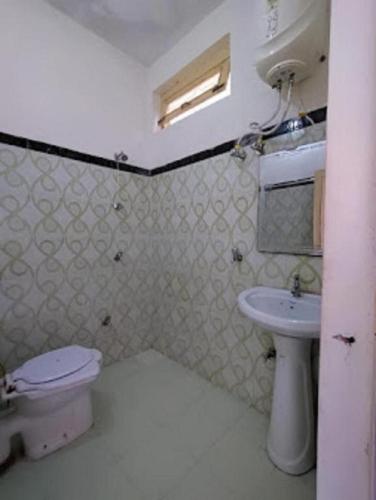 Baño pequeño con aseo y lavamanos en Hotel Mount Hills by StayApart, en Ukhimath