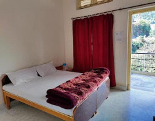 1 dormitorio con 1 cama con cortina roja en Hotel Mount Hills by StayApart, en Ukhimath