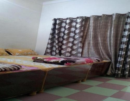 a bed sitting in a room with curtains at Hotel Mount Hills by StayApart in Ukhimath