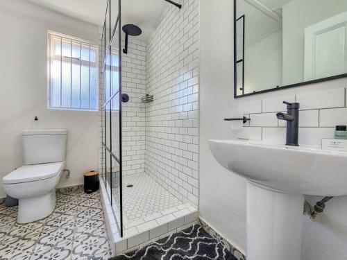 a bathroom with a toilet and a sink and a shower at Classy and Newly Renovated Studio in Observatory in Cape Town