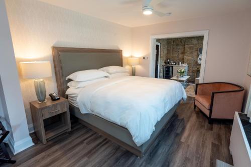 a bedroom with a large bed and a chair at The Glenerin Inn in Mississauga