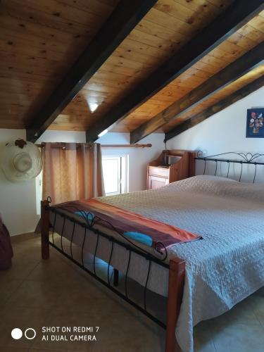a large bed in a room with wooden ceilings at ΘΕΑΛΟΣ ΒΡΑΧΟΣ in Saterlí