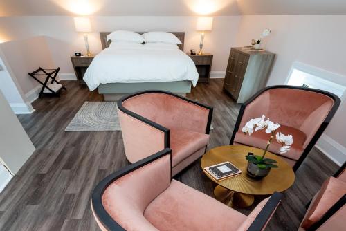 a bedroom with a bed and two chairs and a table at The Glenerin Inn in Mississauga