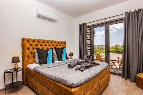 1 dormitorio con 1 cama grande y balcón en Ocean Sunset Villa luxury stay max. 14 people, en Dorp Sint Michiel
