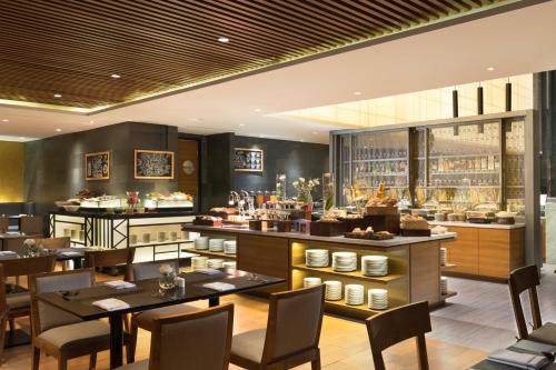 un restaurante con mesas y sillas y un bar en Four Points by Sheraton Jakarta Thamrin en Yakarta