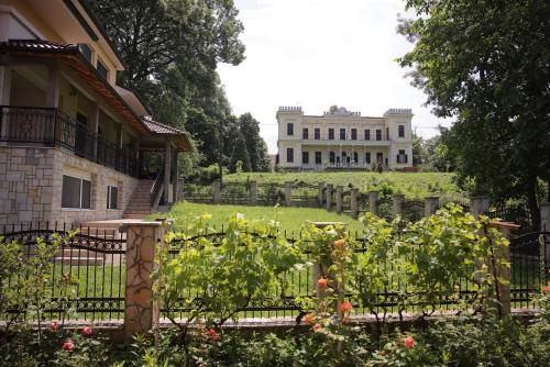 a house with a garden in front of a building at Soho in Vrnjačka Banja